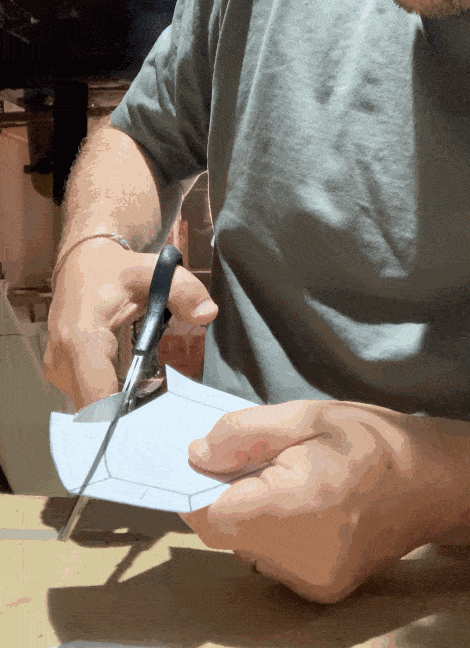 a gif of someone cutting a cartoon with three-bladed scissors