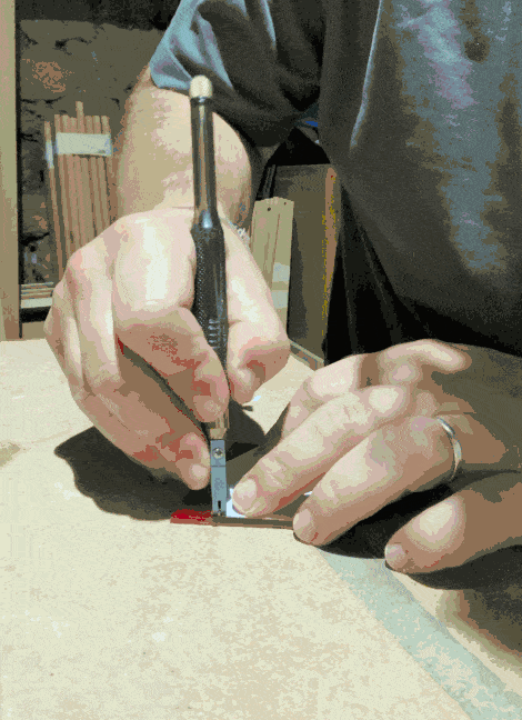 a gif of someone cutting red glass